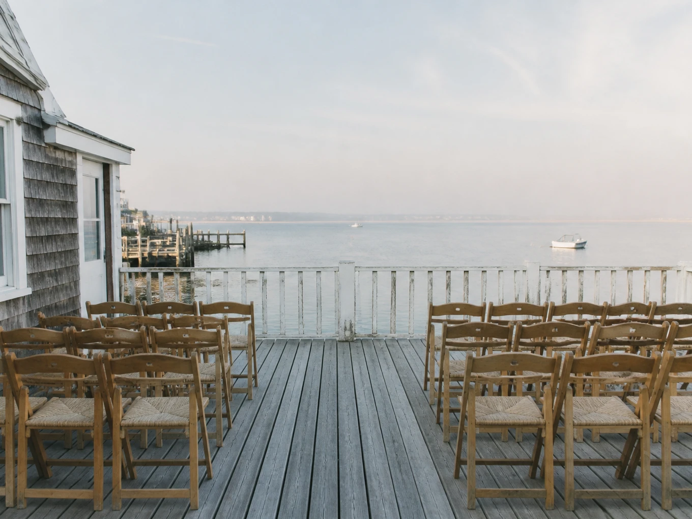 An empty harbor-side ceremony setting in soft morning light